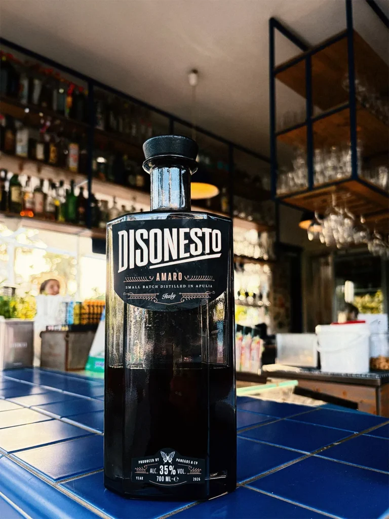 Bottiglia amaro artigianale Disonesto posizionata sul bancone di un locale